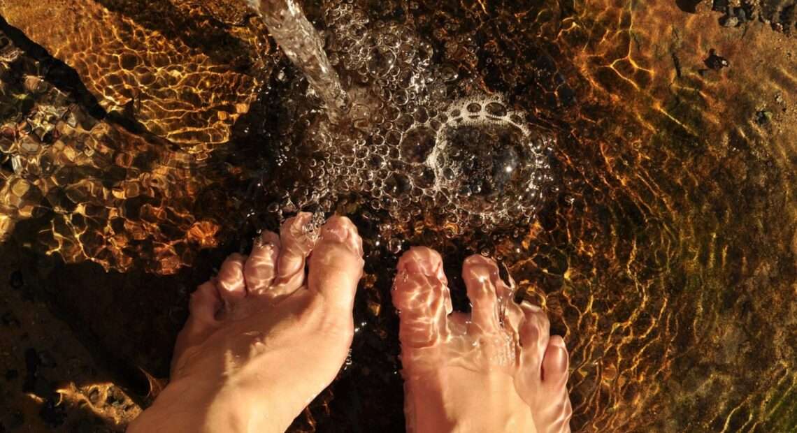 Pies mojándose en el agua del río en una escapada a la sierra de Madrid