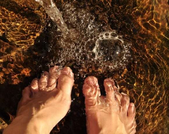 Pies mojándose en el agua del río en una escapada a la sierra de Madrid